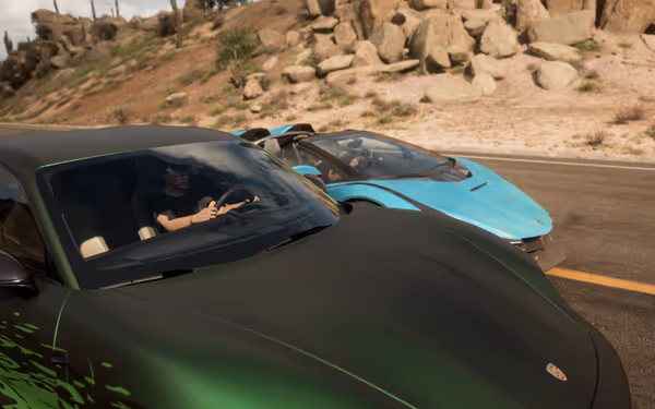Green sports car with black design and blue sports car, both on a desert road.
