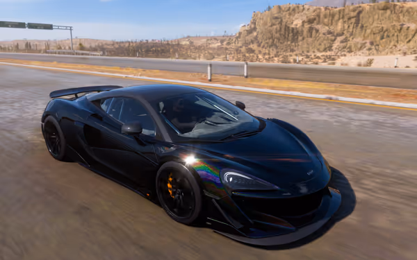 A black sports car with reflective paint drives on a desert highway under clear skies.