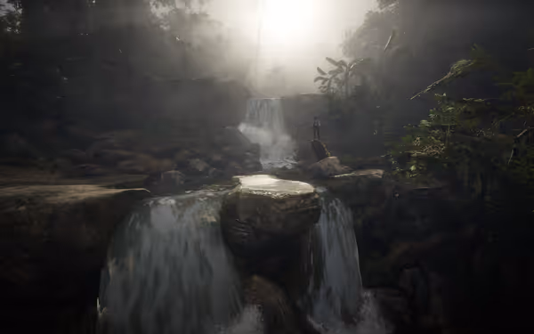 A waterfall cascades over rocks in a misty forest, with a person standing nearby