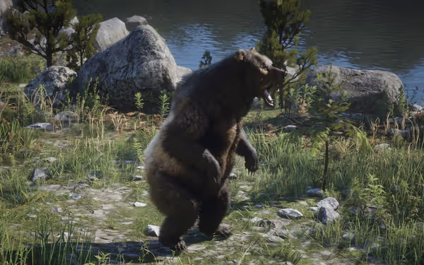Bear standing on hind legs near rocks and water, surrounded by grass and trees.