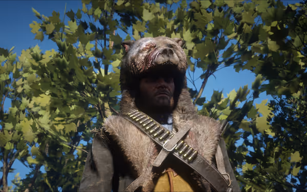 Person wearing bear headgear, bandolier, and fur coat, standing in front of trees.