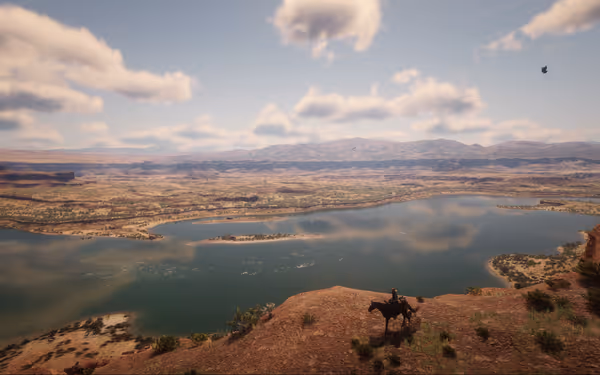 A rider on horseback overlooks a vast lake and desert landscape.