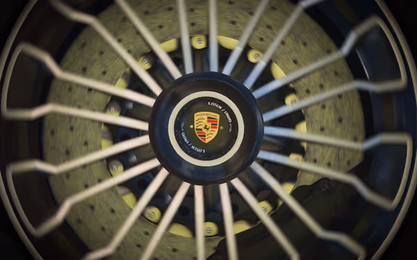 A close up of the Porsche logo on a wheel, edges blurred from the motion of the spinning tire