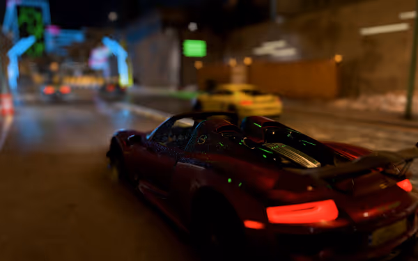 A shiny red car reflecting green neon lights off of its body