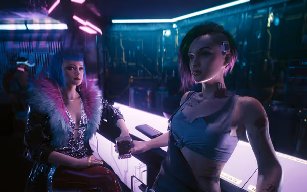 Two stylish women sit at a neon-lit bar, one holding a drink confidently