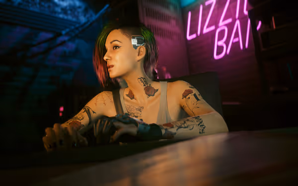 A woman with colorful hair, cybernetic implant, and tattoos sits near a neon bar sign