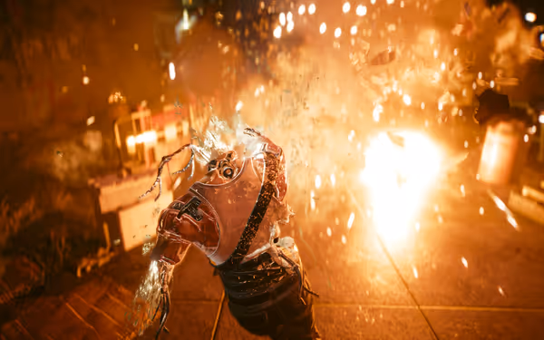 A cybernetic humanoid is disintegrating mid-explosion, with debris and sparks flying everywhere.