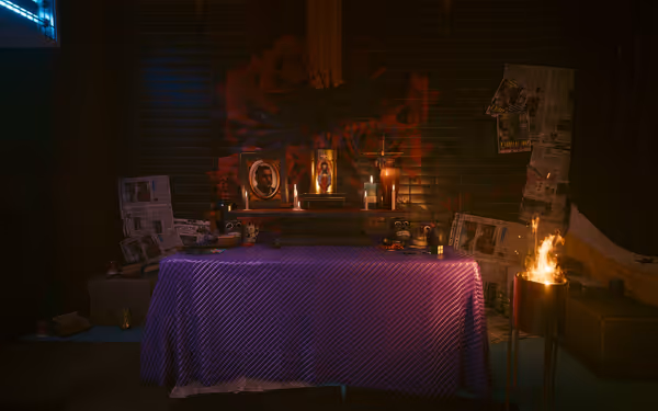 A memorial altar with framed photos, candles, skull decorations, and a small fire burning