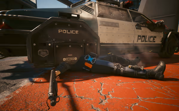A fallen police officer lies behind a riot shield, gripping a shotgun near a patrol car.