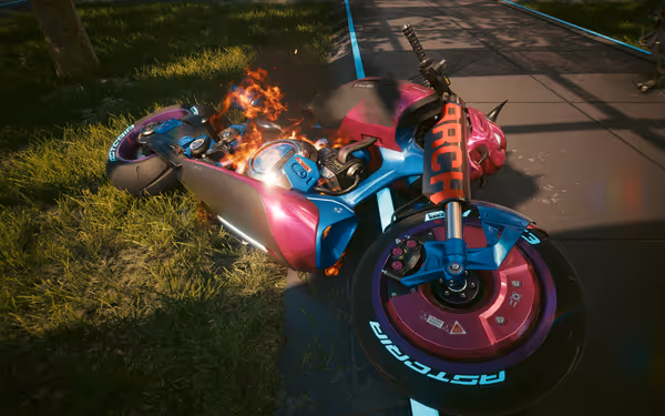 A futuristic pink and blue motorcycle lies on the ground, partially engulfed in flames