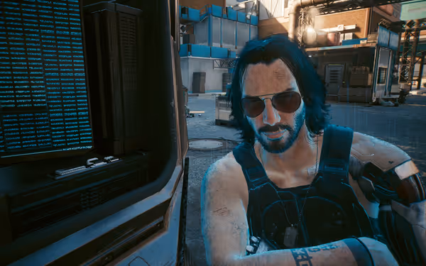 A holographic man with sunglasses and cybernetic arms leans near a futuristic computer screen.