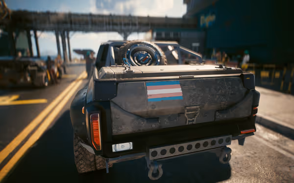 A rugged off-road vehicle with a trans pride flag sticker on its tailgate.