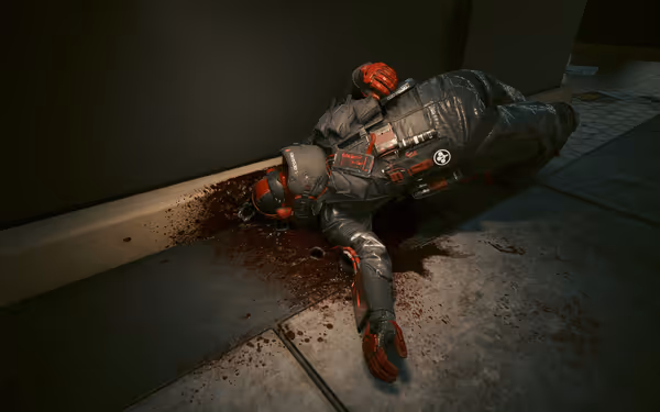 A heavily armored soldier lies dead against a wall, surrounded by blood splatters.
