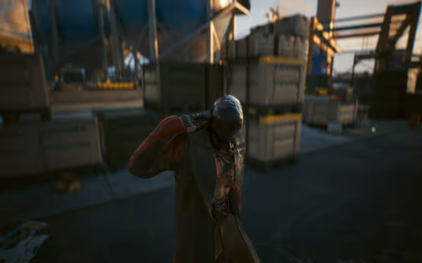 A figure in a long coat and mask holds a gun to their own head