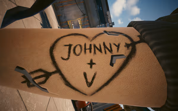 Graffiti heart with “JOHNNY + V” and arrow drawn on a cybernetic arm.