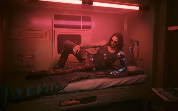 Man with cybernetic arm and sunglasses lounging on a bed under red lighting.