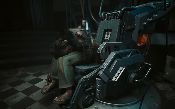 Limp body slumped over a high-tech chair with cables, another figure blurred behind.