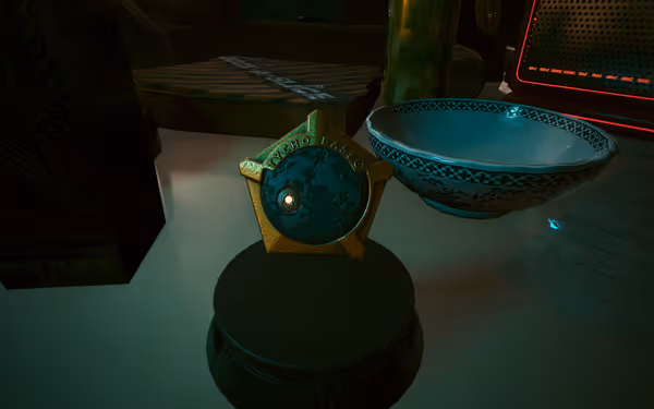 A gold and teal Tycho Base badge sits on a table near a bowl.