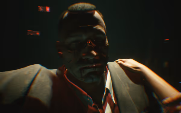 A man with cybernetic implants lies unconscious, with a hand resting on him.