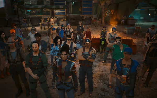 A diverse group of people stand closely together outdoors, facing forward near a campfire.