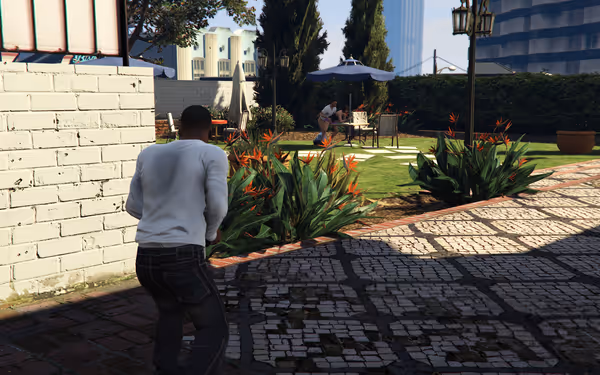 A man in a white shirt sneaks through a garden toward a couple engaging in sex.