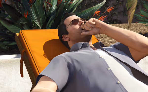 A man in sunglasses lies on an orange lounge chair, yawning.