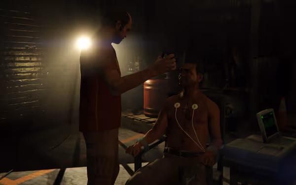 A man holds a device to the head of a shirtless seated man wired to a heartbeat monitor in a dimly lit industrial room