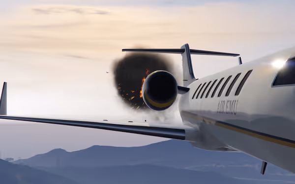 A jet airplane labeled AIR EMU has an engine explosion with fire and black smoke.
