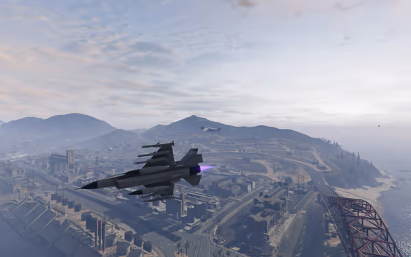 Two fighter jets fly above a city with hills and water in the background.