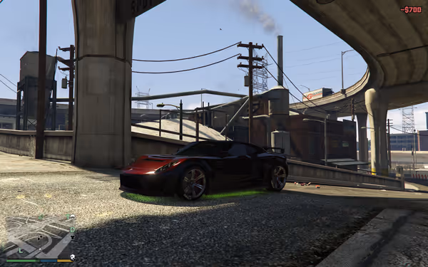 A black sports car with green underglow is parked beneath an overpass.