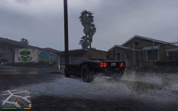 A black sports car drives through rain on a street, splashing water near houses.