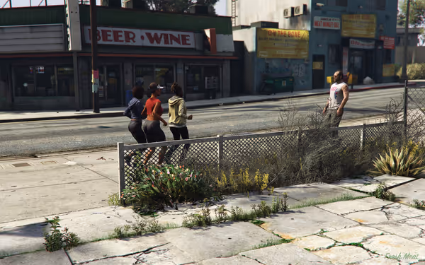 Three women jog on the sidewalk while a man stands across the street watching.