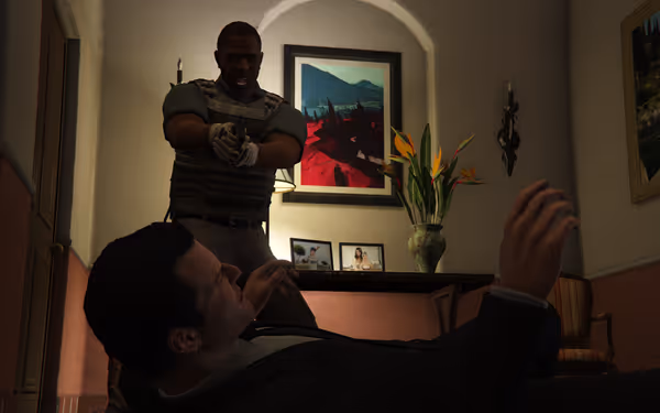 Armed man in tactical gear aiming pistol at another man lying on the ground.