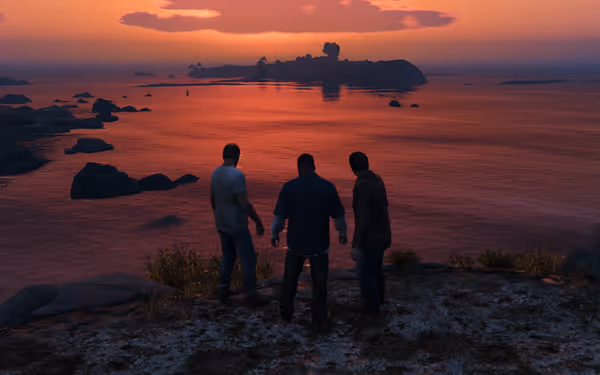 Three men stand on a rocky shore watching a calm ocean at sunset.