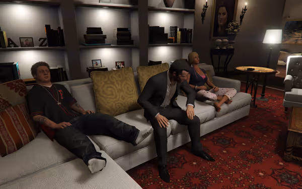 A man in a suit, a woman in pajamas, and another man sit on a couch.