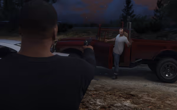 A person stands in front of a red truck with the door open, while another person aims a gun at them from behind.