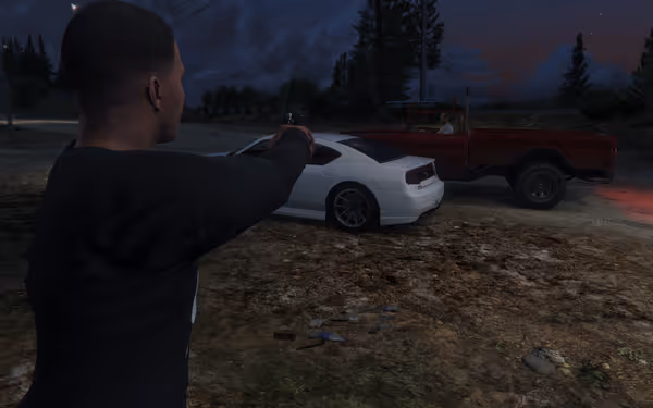 A man looks at a white car and red truck at dusk.