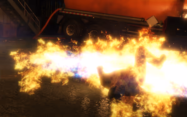 A person is engulfed in flames, lying on the ground near a truck.
