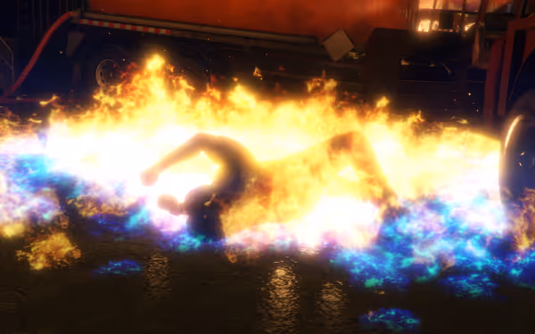 A person lies on the ground completely engulfed in bright orange and blue flames.