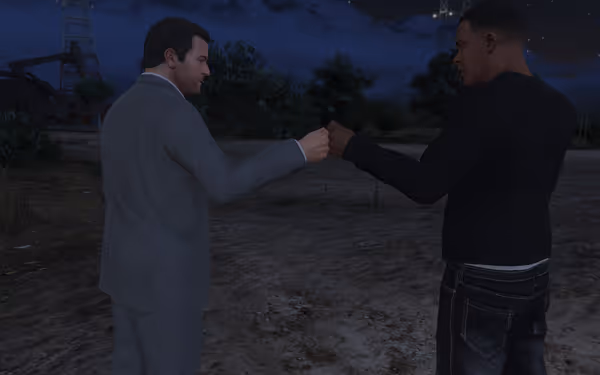 Two people stand outdoors at night, facing each other, doing a fist bump.