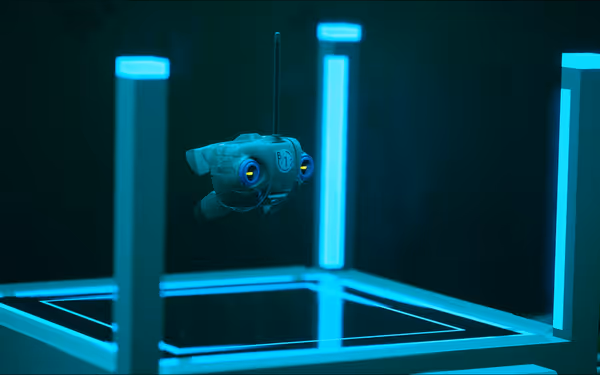 A small robotic creature hovers inside a futuristic platform surrounded by glowing blue columns.